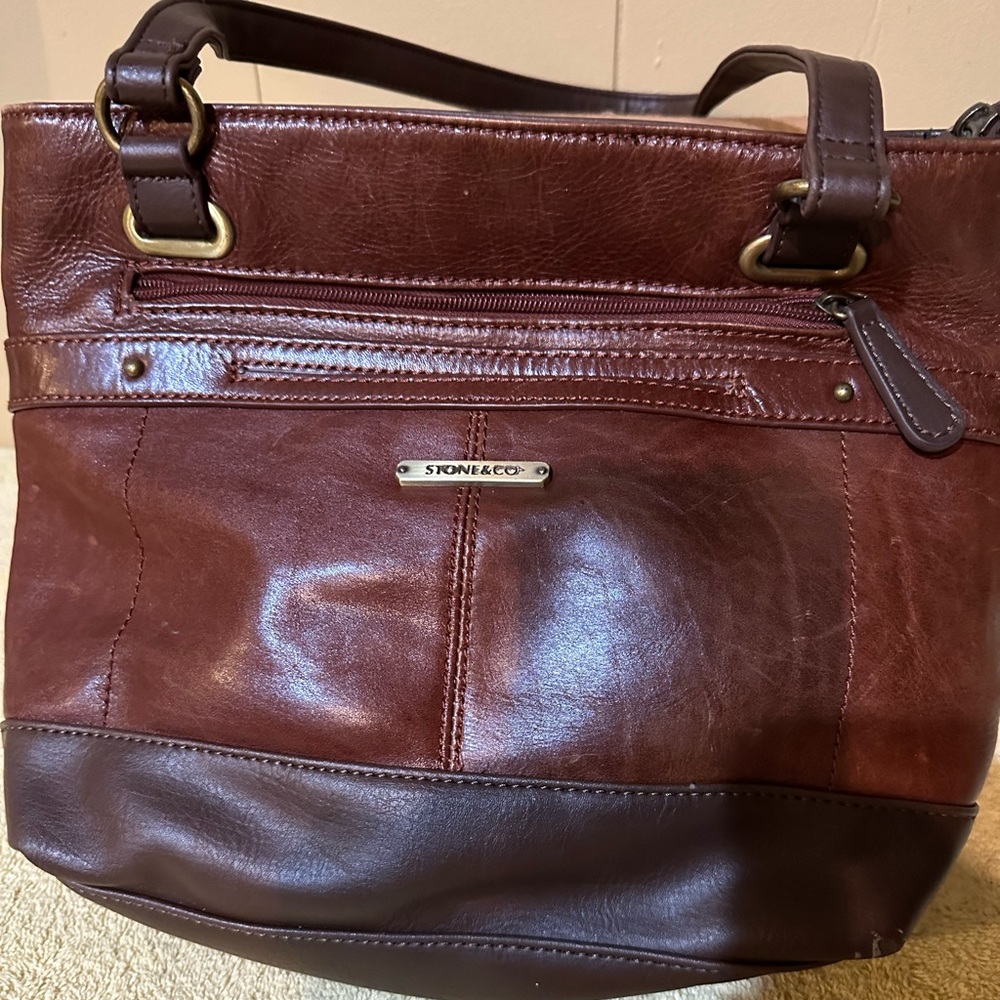 This beautiful bag is made by Stone & Co. It is made of smooth leather